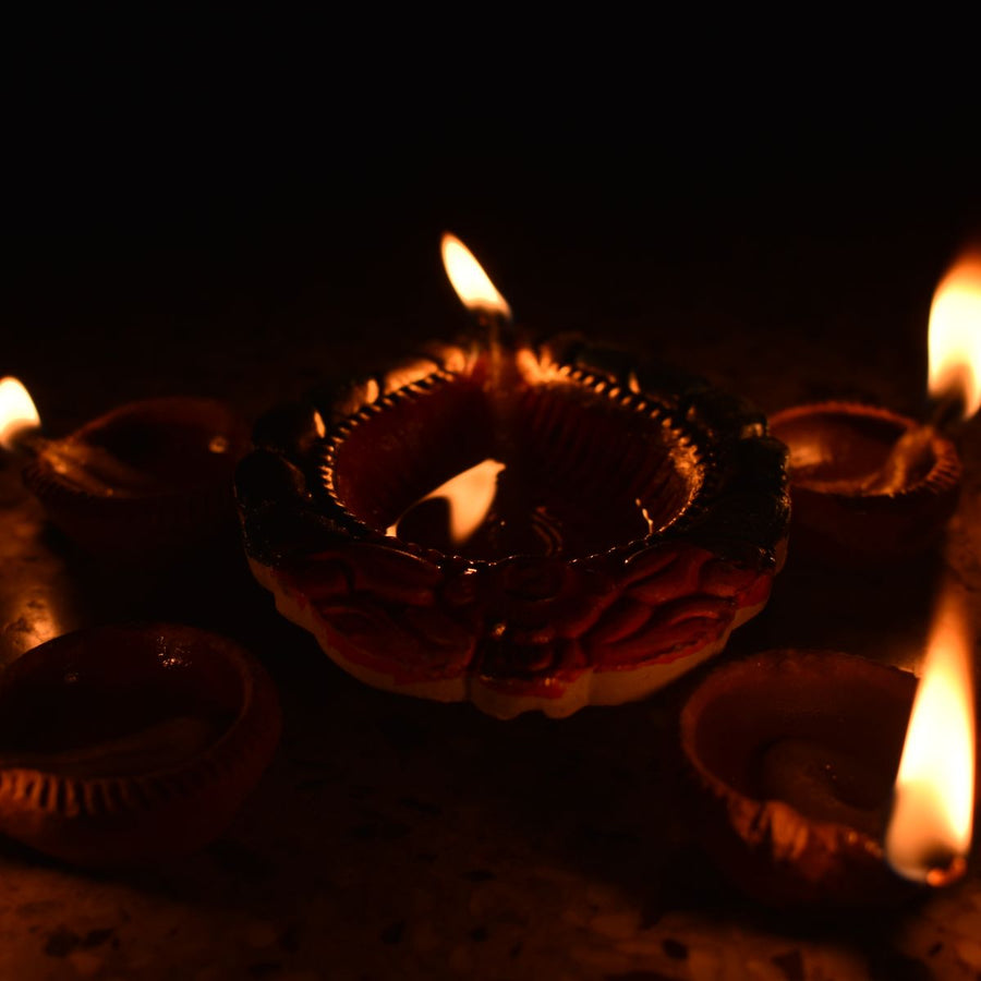 Festive sweets with lit clay diyas